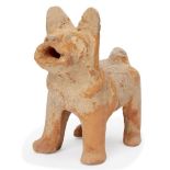 A Chinese pottery model of a dog, Han dynasty, standing foursquare with its head raised in alert