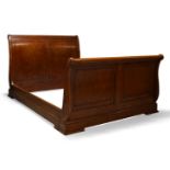 A large mahogany lit en bateau, late 20th Century, with scrolling panelled ends, 122cm high,167cm