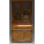 A Victorian mahogany cylinder secretaire bookcase, the moulded cornice above two glazed doors,