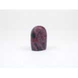 A Chinese red stone seal, of rounded form with decorative carving to the sides depicting a landscape