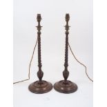A pair of wood turned table lamps, 20th century, with brass fittings to a twisting stem and baluster
