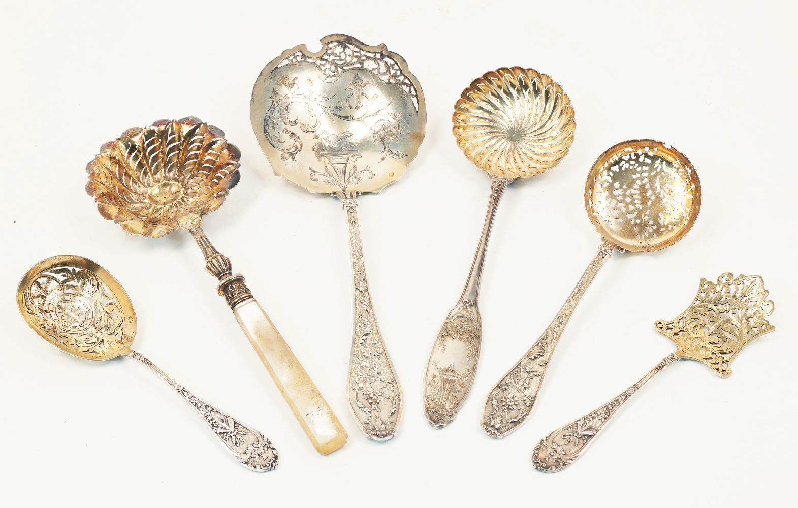 A group of six French silver straining spoons and servers, various designs and makers including a