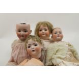 A group of four bisque headed dolls, 20th century and later, in varying conditions, some with