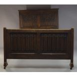 An oak bed in the Gothic taste, early 20th Century, the panelled headboard with carved Gothic arches