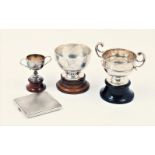 Three silver trophy cups and a silver cigarette case, the trophy cups of varying form and size,