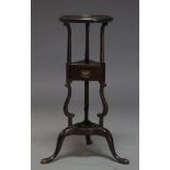 A George III style mahogany wig stand, early 20th Century, the circular top on scrolling supports to