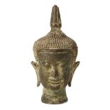 A bronze head of Buddha, possibly Thai, with characteristic long lobed ears and curled hair, eyes