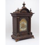 An Edwardian oak bracket clock, of architectural form with a semi-circular tympanum flanked and