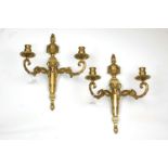 A pair of French gilt bronze two branch wall lights, early 20th century, set with ram's mask motif