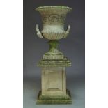 A large composite urn on stand, 20th Century, with flared rim and handles emitting from mythological