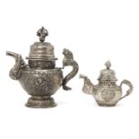 Two Tibetan white metal teapots, early 20th century, each repousse decorated with mythical beasts