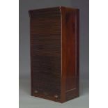 An Edwardian mahogany tambour fronted cabinet, the tambour shutter enclosing three shelves, 122cm