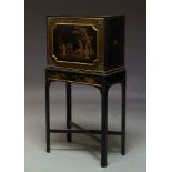 A black lacquered and Japanned cabinet on stand, early to mid 20th Century, the fall decorated