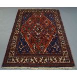 A shiraz rug, with floral motifs in a red field, with ivory main border, 200cm x 132cm, together