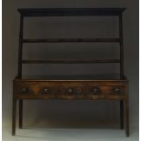 A George III oak dresser, the plate rack with moulded cornice above two shelves, the base with three