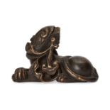 A Chinese bronze lion dog scroll weight, Ming dynasty, 17th century, modelled in recumbent pose