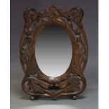 A carved oval wall mirror, 20th Century, with oval plate set within pierced and foliate carved