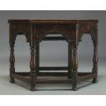 An oak credence table, early 20th Century, with folding octagonal top, above arcaded frieze on