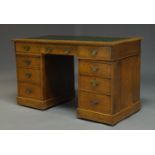 An oak pedestal desk, late 19th Century, the rectangular top inset with green leather writing