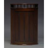 A mahogany corner cupboard, early 20th Century, of bow front form, the galleried top above