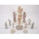 A collection of cherubic figurines, 20th century, to include a larger example of Cupid seated on a