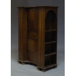 An oak secretaire cabinet, c.1930, the shaped top above fall enclosing writing surface and three