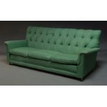 A three seater sofa, late 20th Century, upholstered in green button back fabric, with three loose