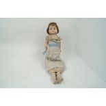 A Victorian composition doll, circa. 1860-70, with brown hair, set with blue glass eyes, fabric body