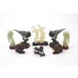 A group of jadeite and hardstone carvings on carved and pierced wood stands, to include a pair of