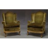 A pair of George III style wing back arm chairs, early to mid 20th Century, with curved wings and