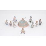 A collection of eight porcelain tea cosy dolls, of various different colour ways and designs,