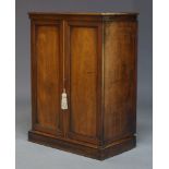 A Victorian and later mahogany cabinet, with two panelled doors enclosing one shelf, raised on