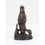 A soapstone figure of Guanyin, 20th century, carved pouring water into a dragon's mouth, 29cm