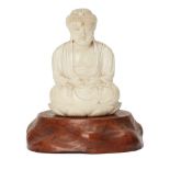 A Chinese ivory figure of Buddha, early 20th century, carved seated on a lotus base, 8cm high, on