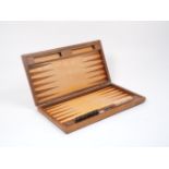 A walnut travelling backgammon board, 20th century, of typical form, the quarter cut veneered