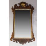 A George III mahogany and parcel-gilt fretwork mirror, with carved fretwork crest and apron, the
