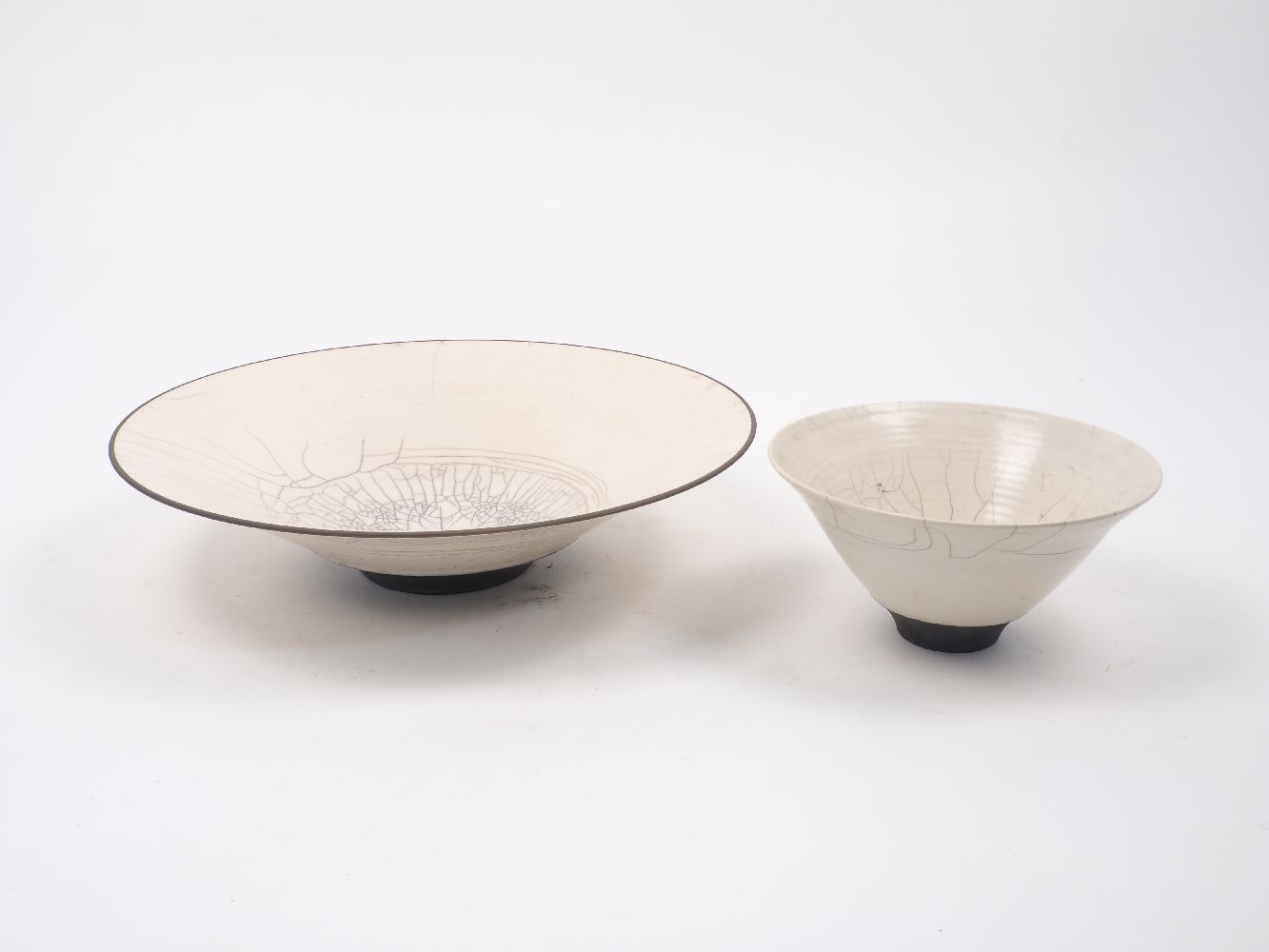 Rudi Delanghi, a raku white crackle-glazed shallow bowl on black foot, signed and dated ‘89’, 39cm