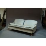 A three seat sofa, possibly George Smith, raised on brass casters and turned wood legs, George Smith