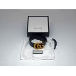 A Gucci GG leather belt, designed with characteristic 'GG' logo antiqued brass buckle, to a black