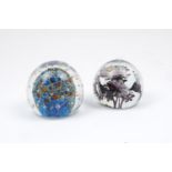 Two paperweights of modern design, the former with blue and orange centrepiece and glass bubbles,