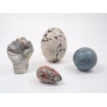 A group of four marbled effect wood turned objects, to include a raised clenched fist, 20cm high,