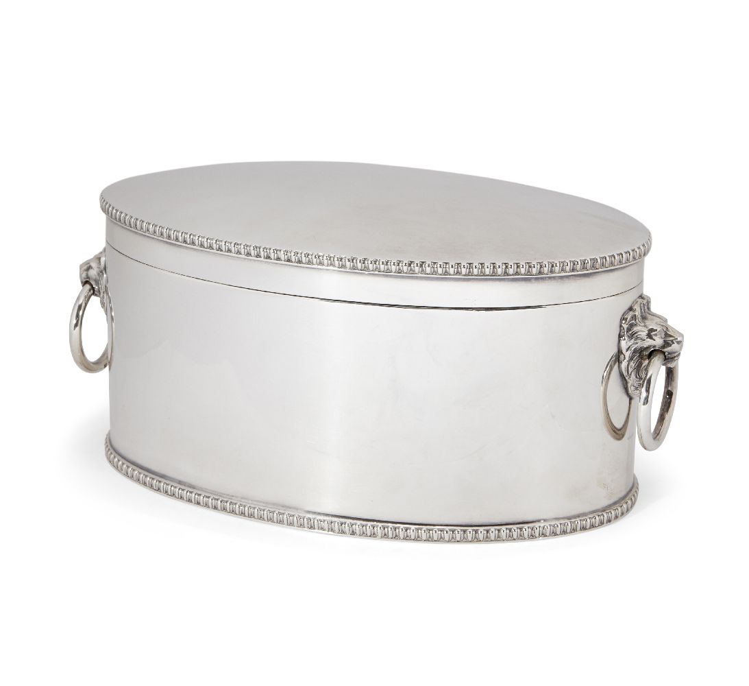 An oval silver biscuit box, Sheffield, 1928, Atkin Brothers, with applied lion mask ring handles