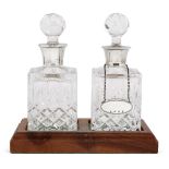 A pair of silver mounted glass decanters on wooden base, Birmingham, c.1985 and 1988, Charles S
