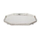 An elongated octagonal silver tray, Birmingham, c.1924, Albert Edward Jones, raised on four ball