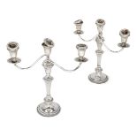 A pair of three-branch candelabra candlesticks, bases stamped 'weighted sterling', each