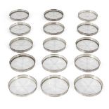 A set of fifteen cut glass and white metal coasters, star motif to each glass base, the sides