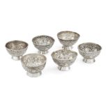 A set of six white metal salts, unmarked, assumed Indian silver, of circular form, each richly
