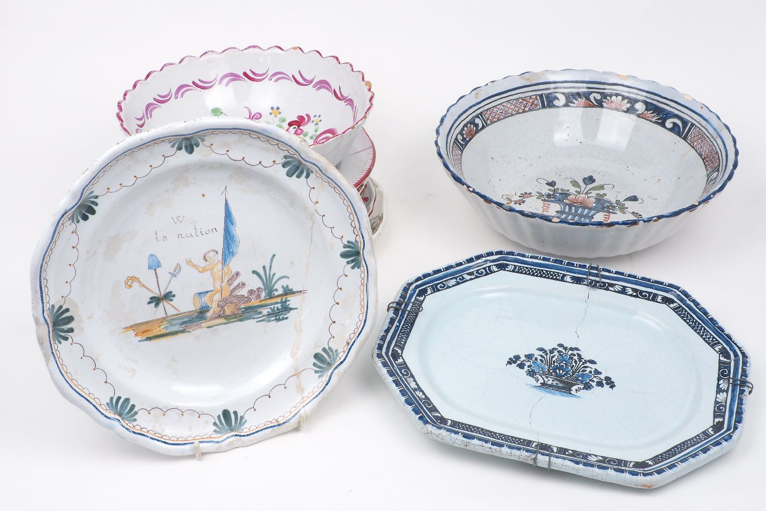 A collection of continental tin-glazed earthenware platters and bowls, late 19th century and