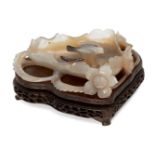 A Chinese agate brushwasher, 19th century, carved as a lotus with leafy stems issuing blooming