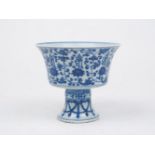 A Chinese porcelain stem cup, 20th century, painted in underglaze blue with flowers issuing from